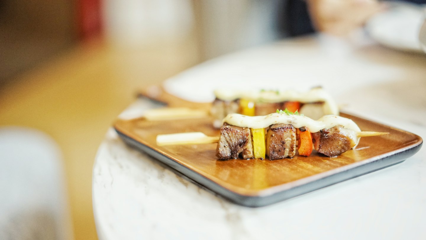 Grilled meat skewers with peppers on a wooden board.