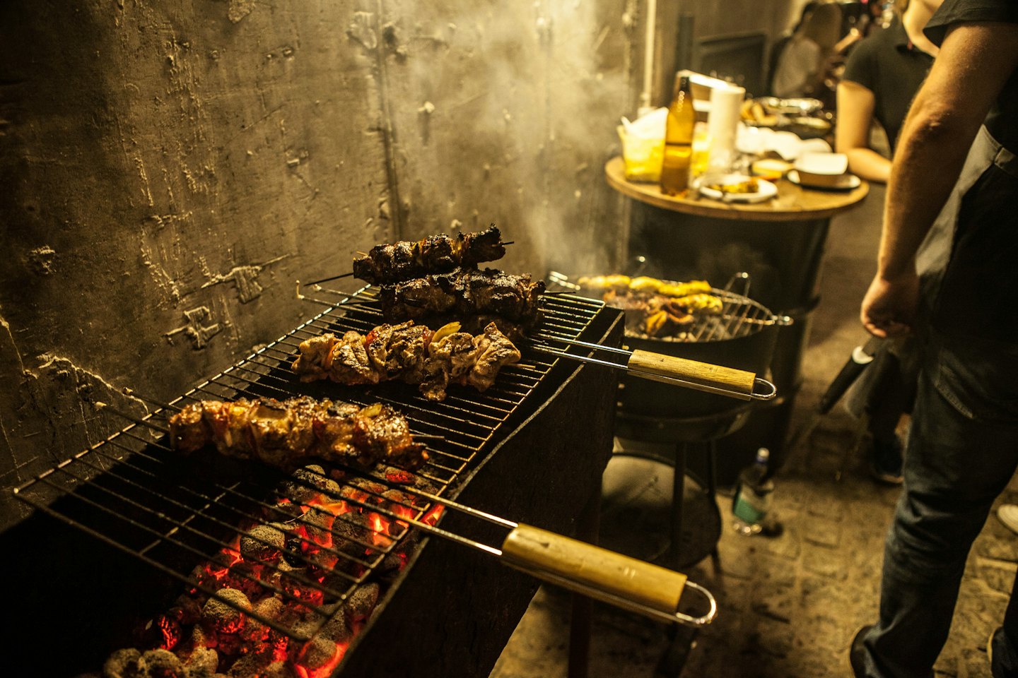 Skewers of meat and vegetables grill over hot charcoal coals.